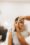 Plastic surgeon drawing dashed lines around eyes of girl, above her eyebrow. Hands in blue glove